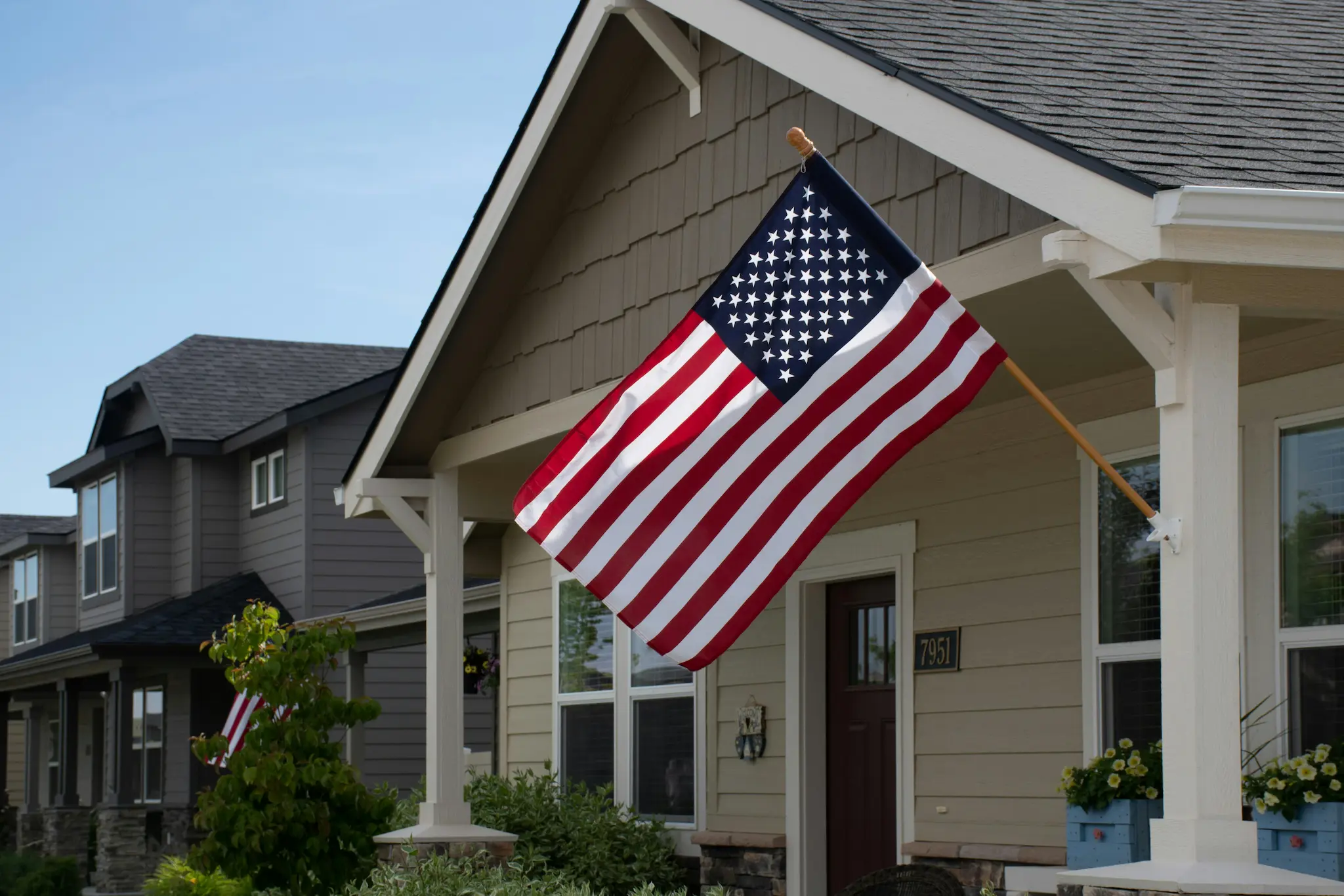 Residential house with a large American flag mounted near the front entrance